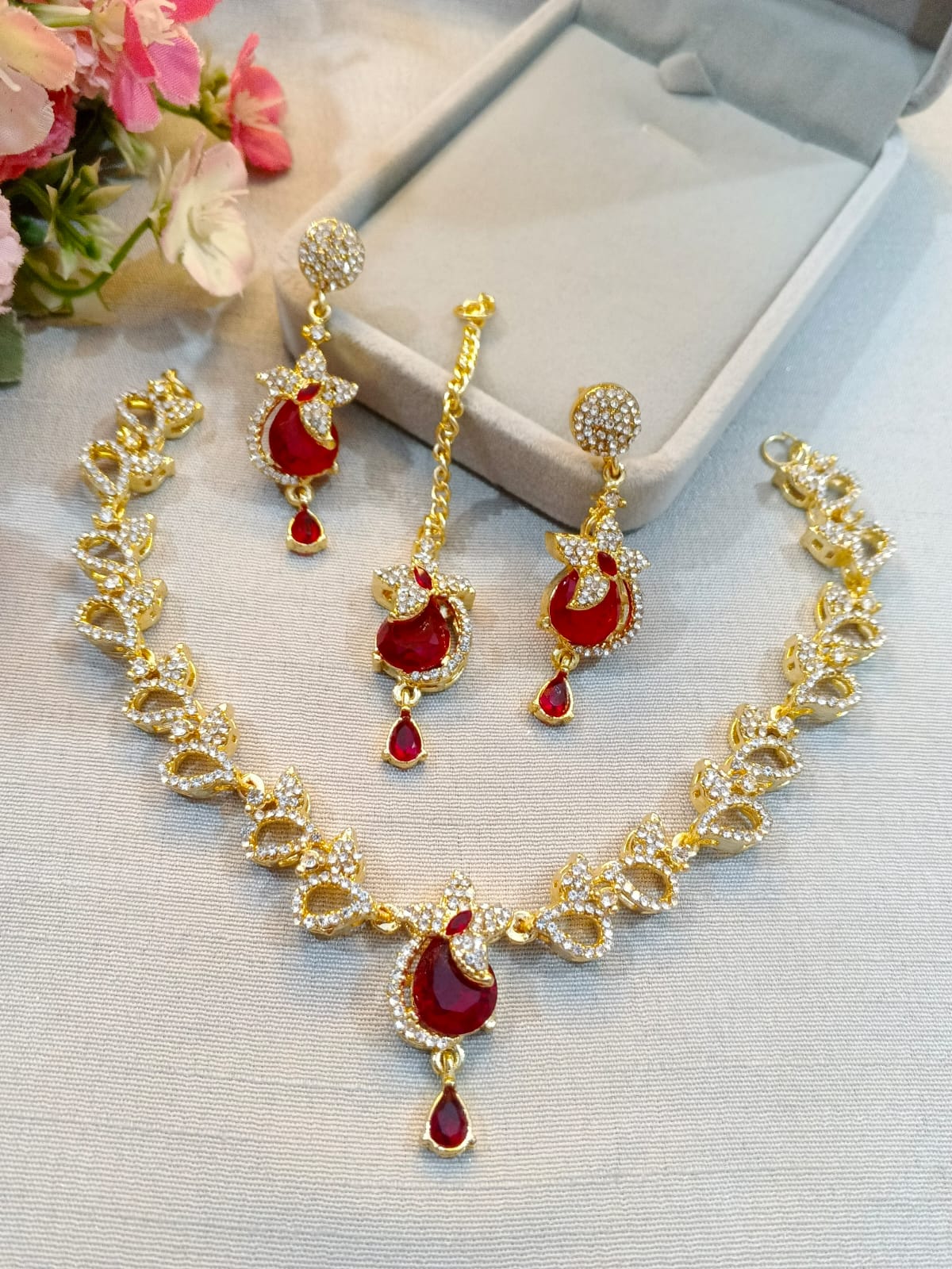 Gold polish zircon necklace set with earrings and tikka, ruby red stones
