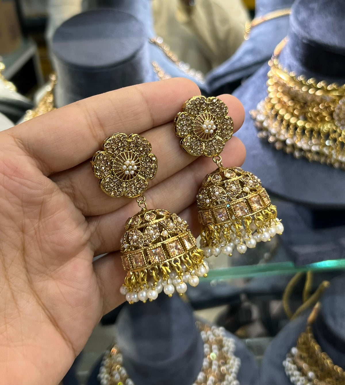 Antique gold jhumka earrings with champagne stones and pearl drops